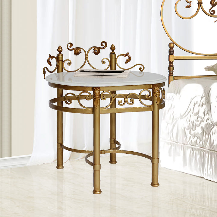 A luxurious wrought iron bedside table inspired by the neoclassical style painted in an antique gold finish