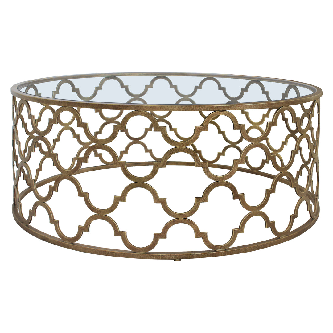 A modern metallic coffee table with a quatrefoil geometric pattern topped with clear glass