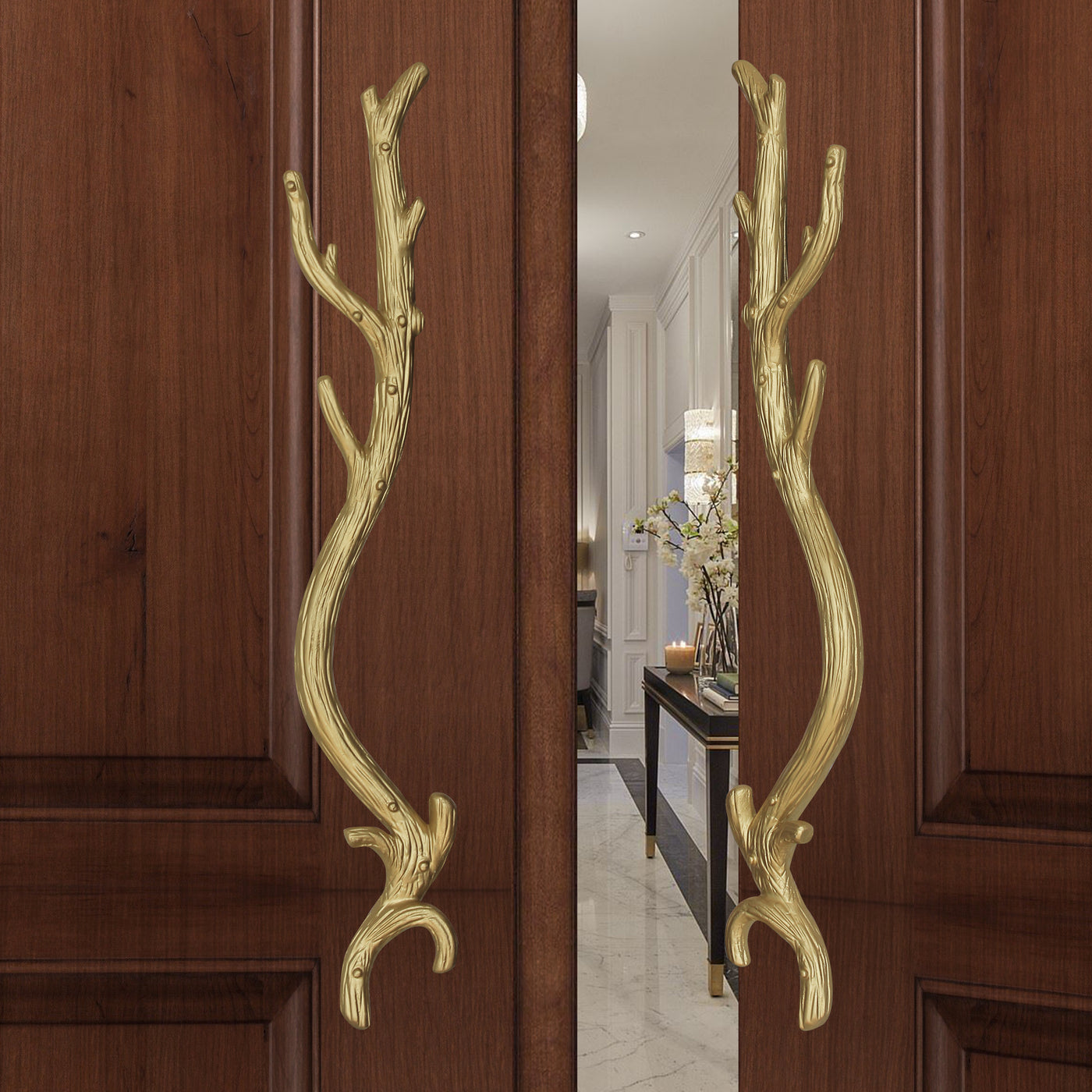 A pair of gold decorative pull handles inspired by branches mounted on an opened wooden door