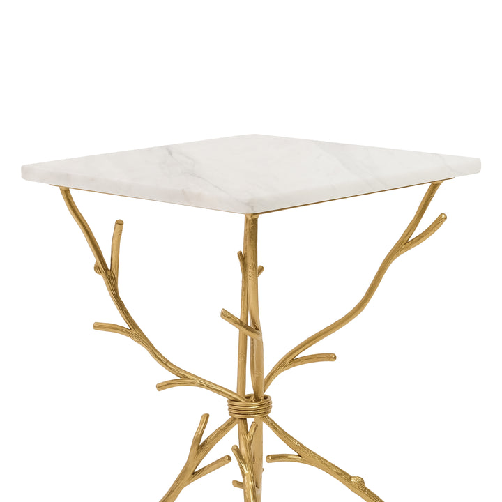 Top portion of a unique accent table with golden legs that look like branches