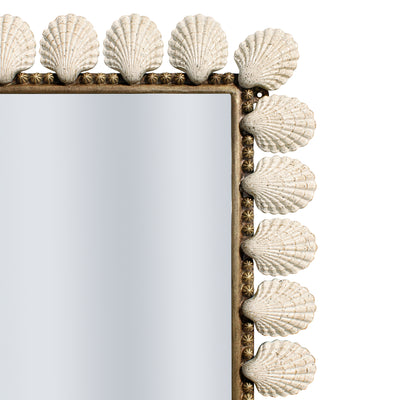 Close up of a unique mirror inspired by marine life with metal seashells along its perimeter, painted in an antique white rustic finish