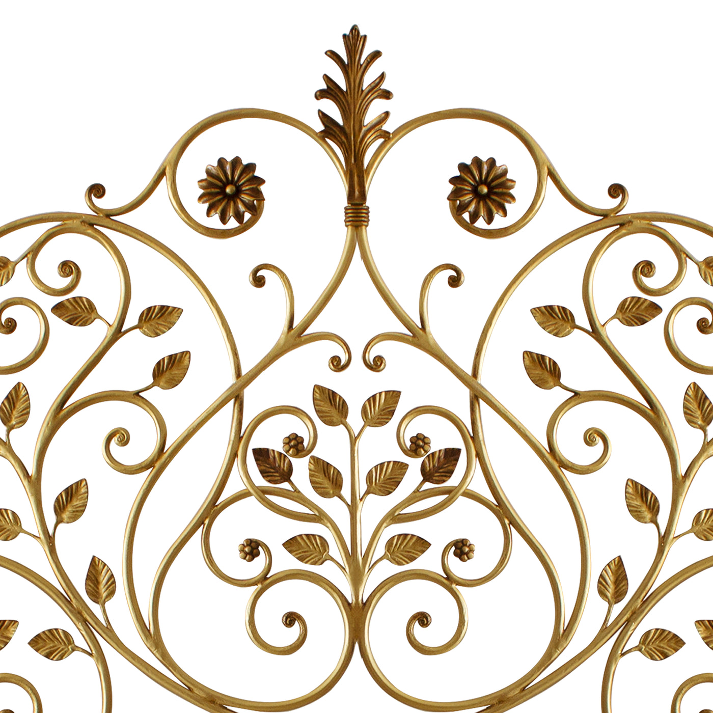 Close up of a wrought iron headboard made up of scrolls, leaves and flowers painted in an antique golden finish