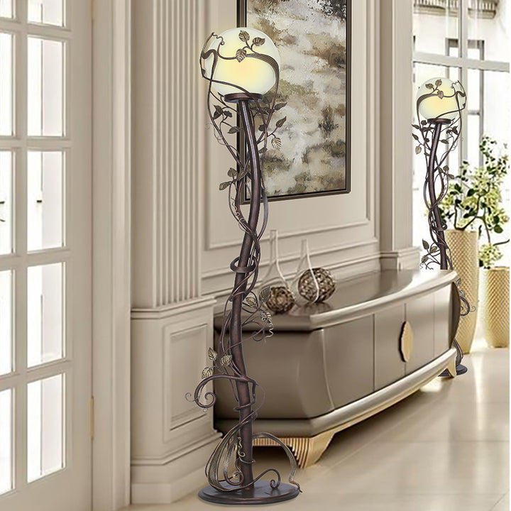 Two luxurious wrought iron decorative floor lamps made up of stems and leaves, stand in a luxurious living space