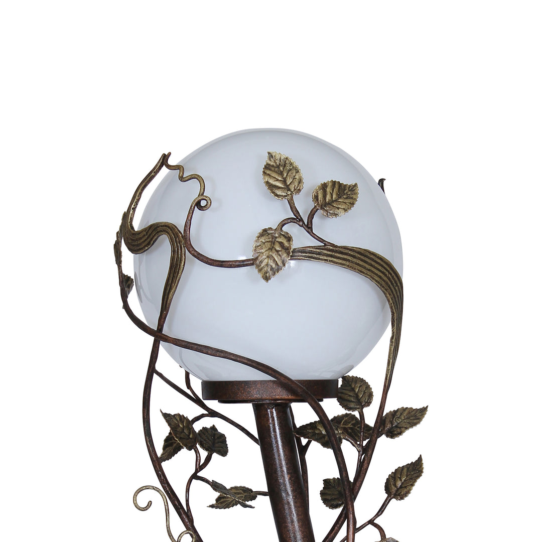 Close up of luxurious wrought iron decorative floor lamp made up of stems and leaves, painted in an antique bronze finish