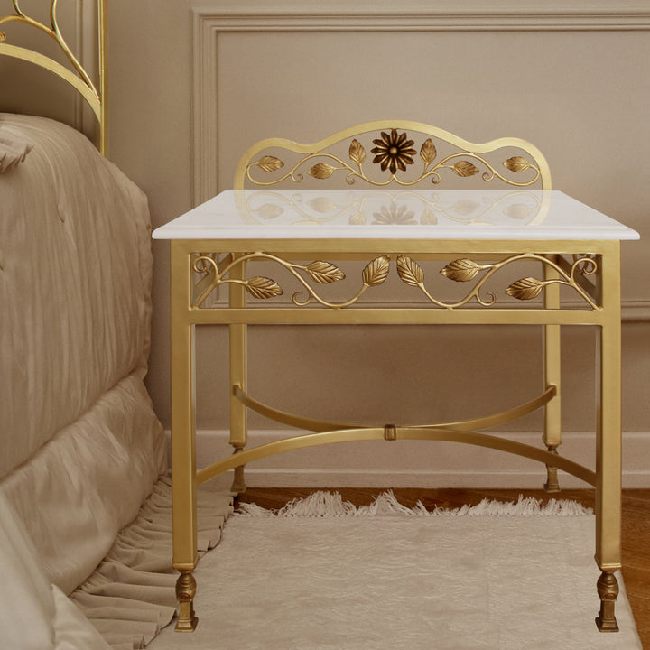 Luxurious wrought iron bedside table inspired by nature painted in an antique gold finish