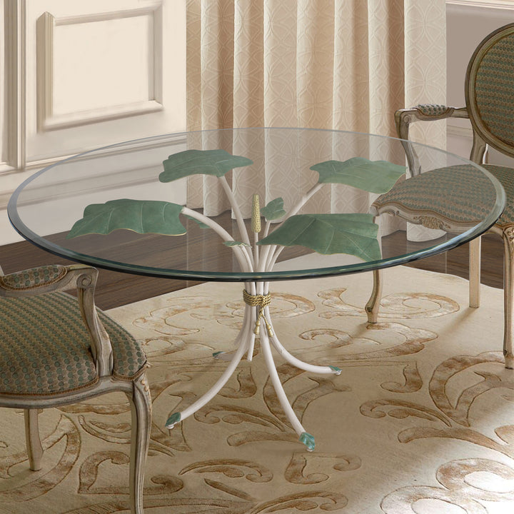A contemporary round entry table with a nature inspired iron base, topped with clear glass in a luxurious living space