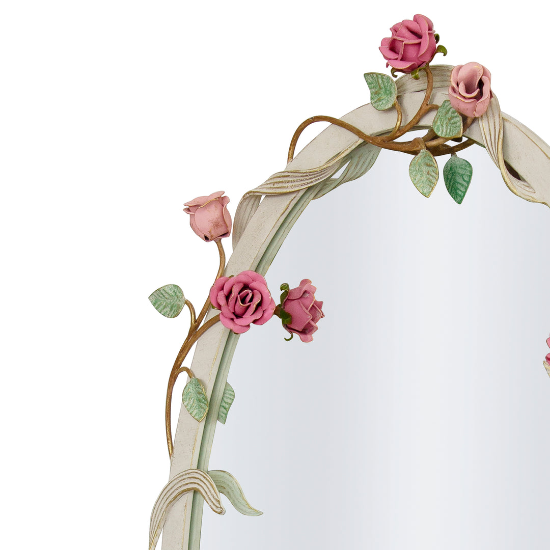 Close up shot of a floral themed, oval shaped mirror with metal forged roses and branches wrapped along its border