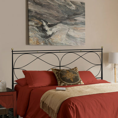 A contemporary wrought iron double bed painted in black and hints of gold, with red beddings