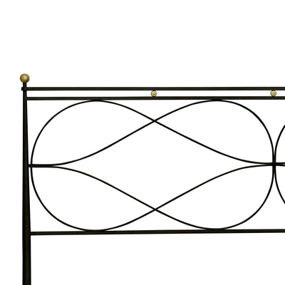 Close up of a modern wrought iron bed painted in black and hints of gold