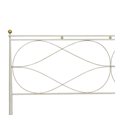 Close up of a modern wrought iron bed painted in white and hints of gold