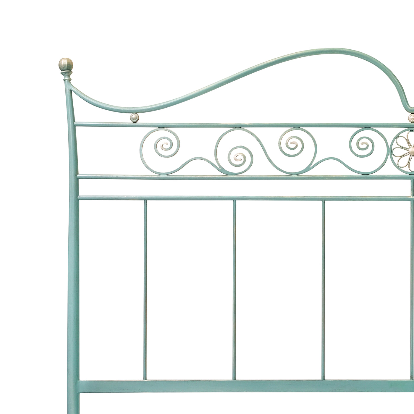 Close up of an iron handmade classical bed with ornamental scrolls painted in blue with hints of silver