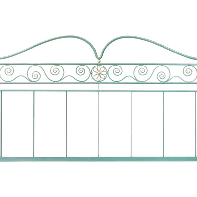 Close up of a metal forged classical bed with ornamental scrolls painted in a pastel blue with hints of silver