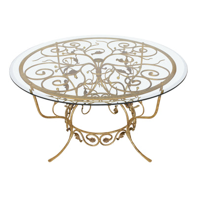 A majestic round entrance table with a classical wrought iron base, topped with a clear circular beveled glass