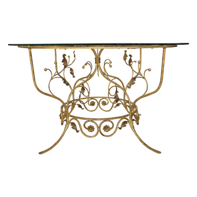 A majestic round foyer table with a classical metal forged base, topped with a clear circular glass