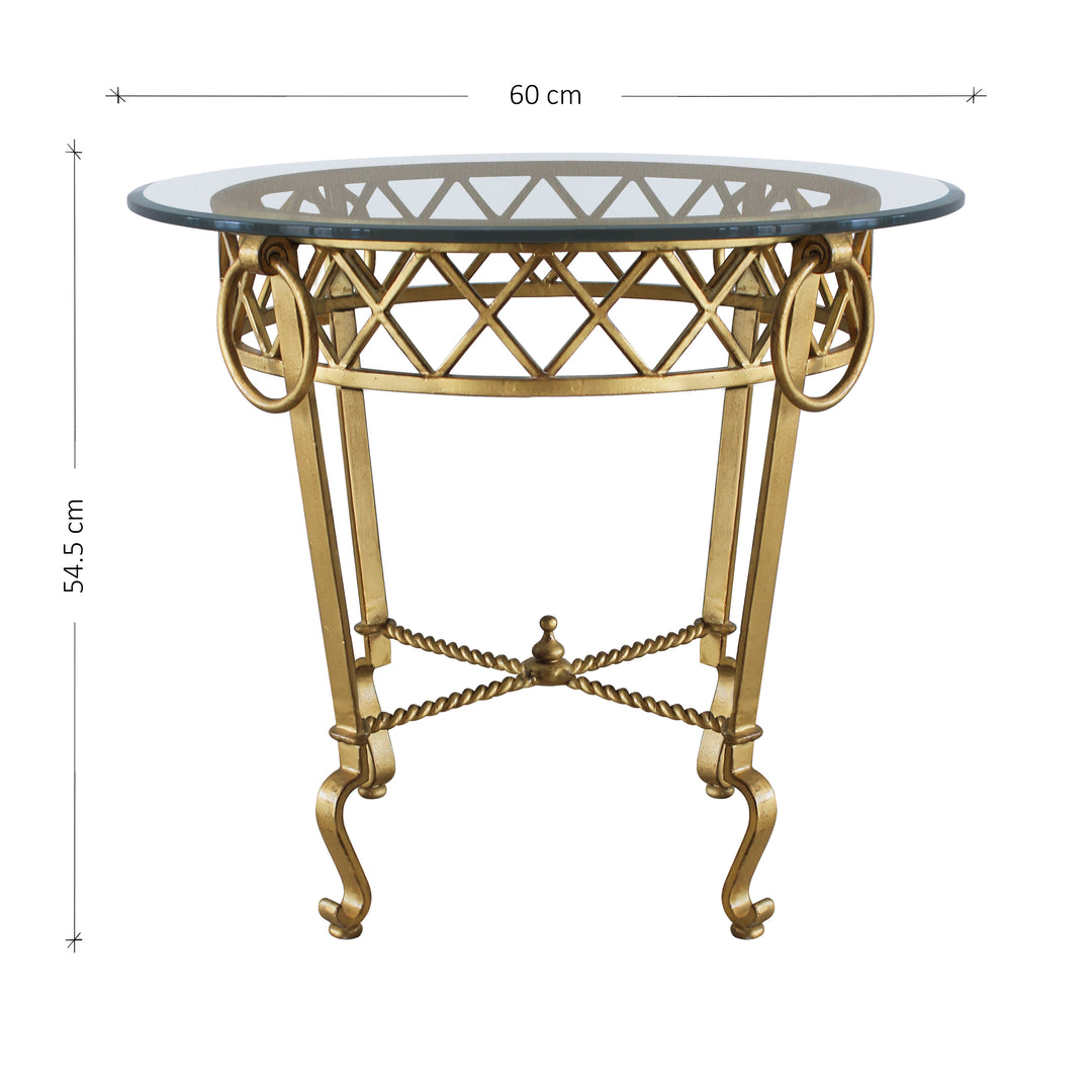 A luxurious side table made of wrought iron in antique gold finish with a clear glass top