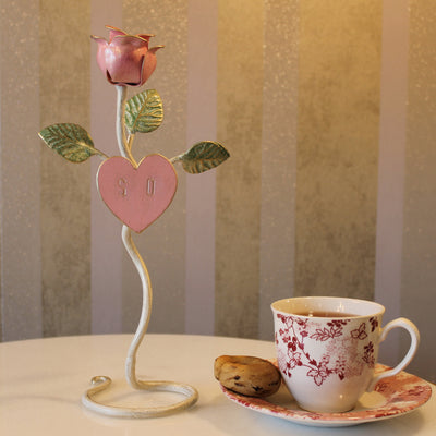 A decorative handmade metal pink rose stand with engraved initials