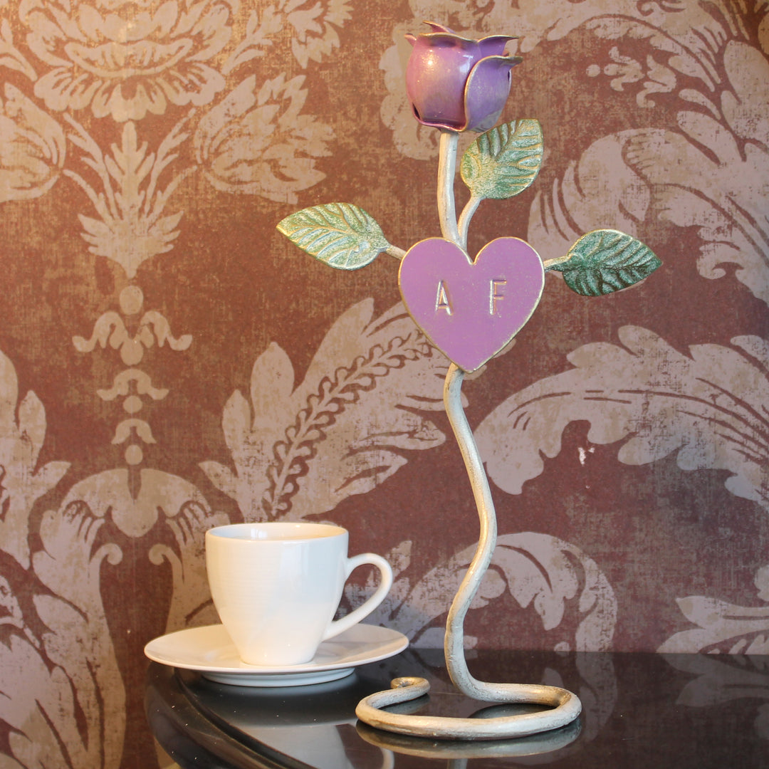 A decorative handmade metal purple rose stand with engraved initials